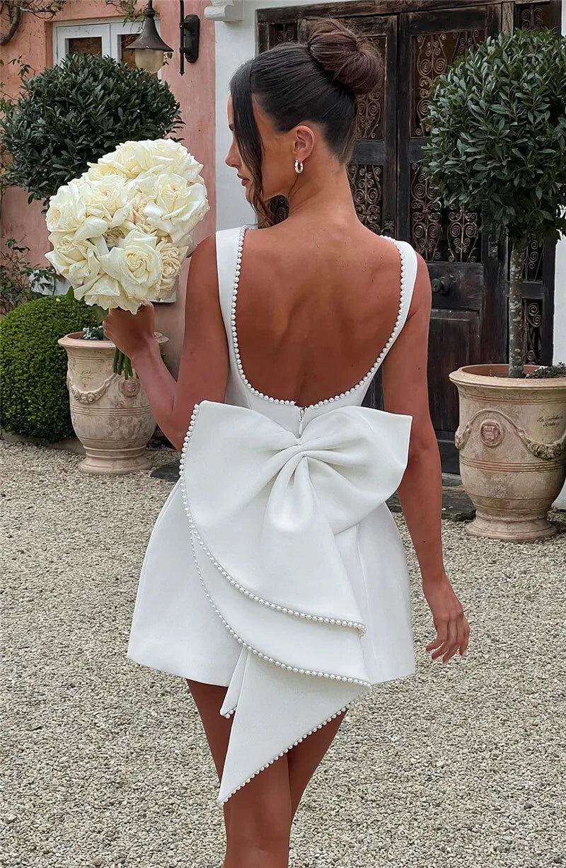 Open-back A-line mini dress with pearl and bow decoration on back - April