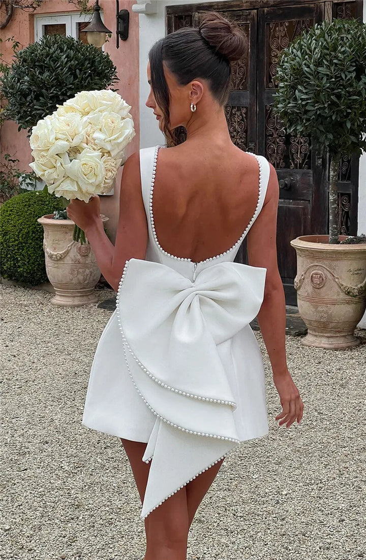 Open-back A-line mini dress with pearl and bow decoration on back - April