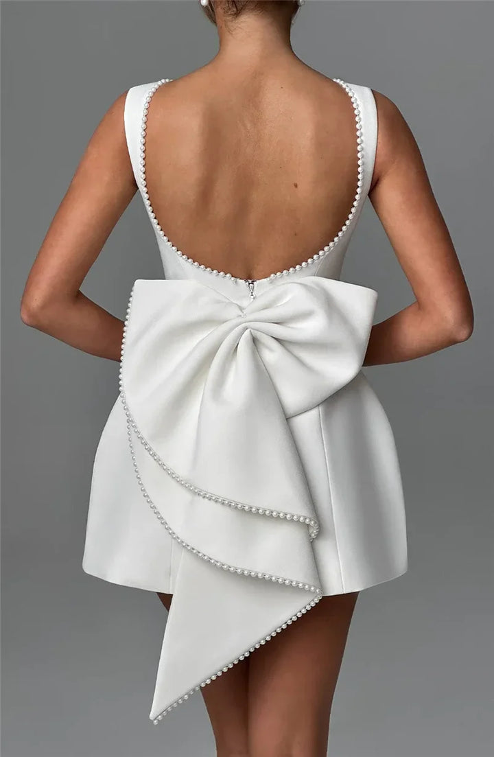Open-back A-line mini dress with pearl and bow decoration on back - April