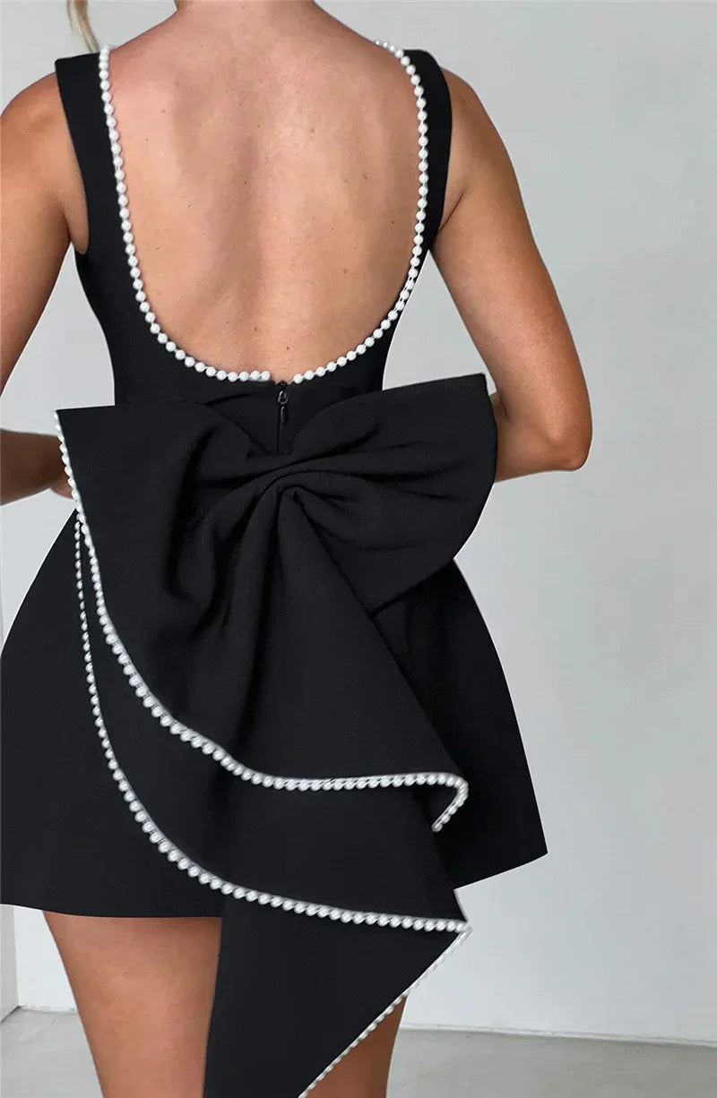 Open-back A-line mini dress with pearl and bow decoration on back - April