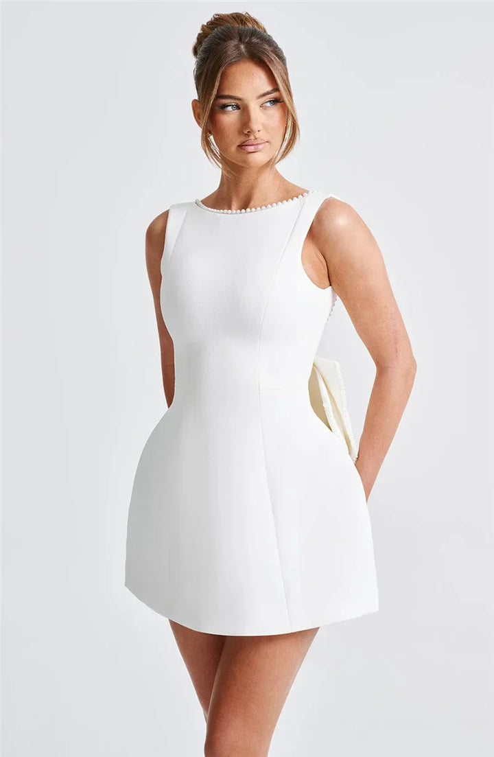 Open-back A-line mini dress with pearl and bow decoration on back - April